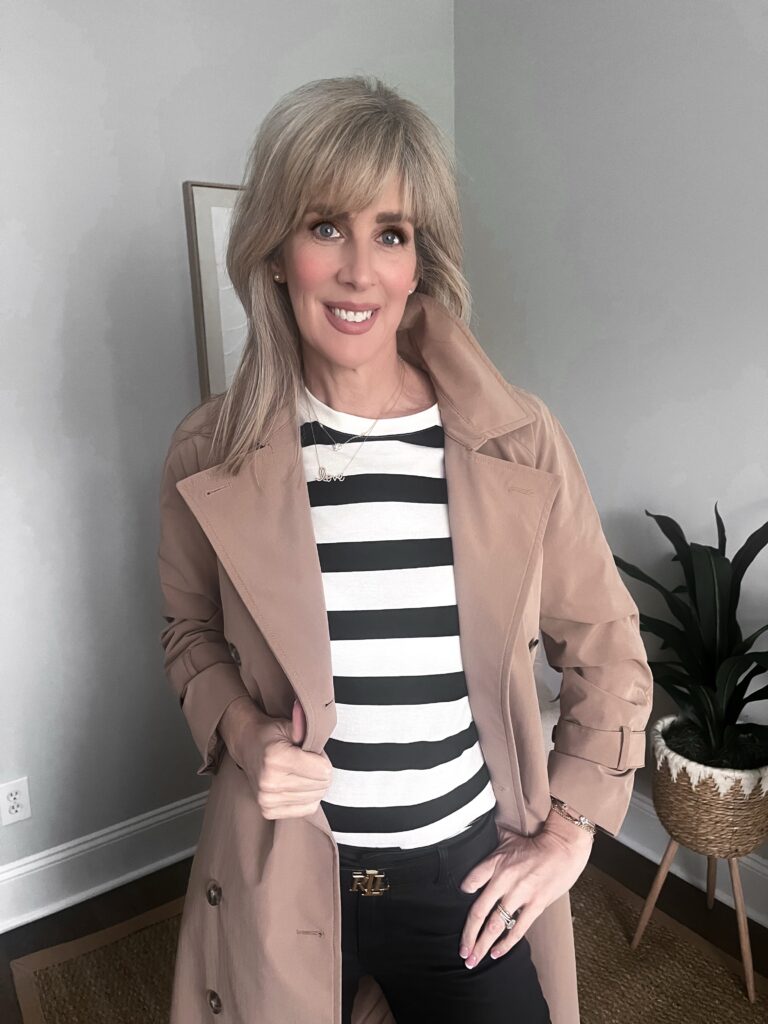 french girl style, woman wearing striped top, trench coat and black denim with ballet flats