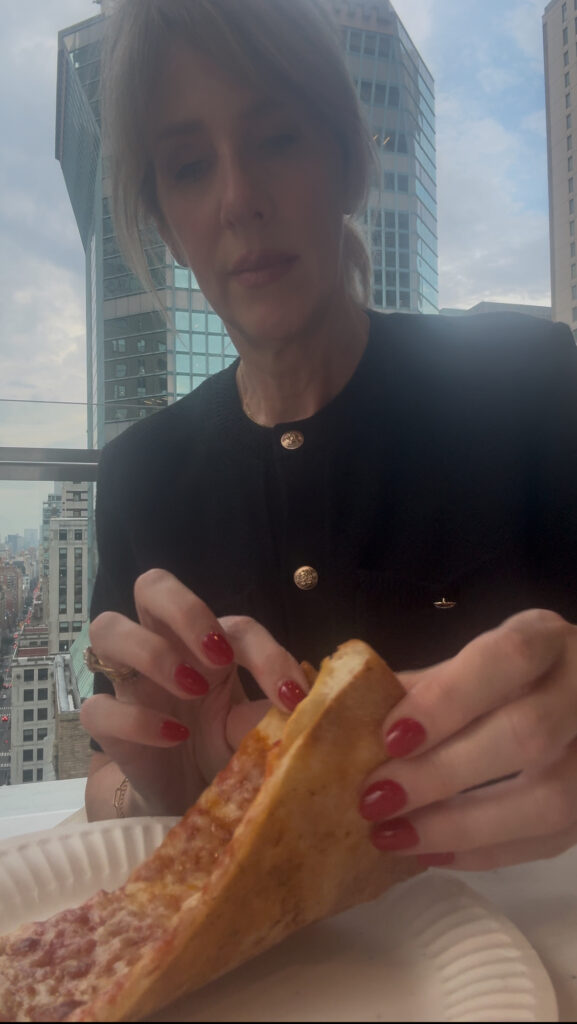 best nyc hotels, woman eating pizza at the rooftop terrace at Club Quarters Grand Central